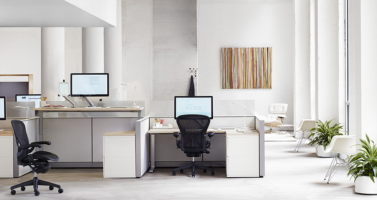 brightly lit office space. segmented desk space featuring the Herman Miller Aeron office chair in black.