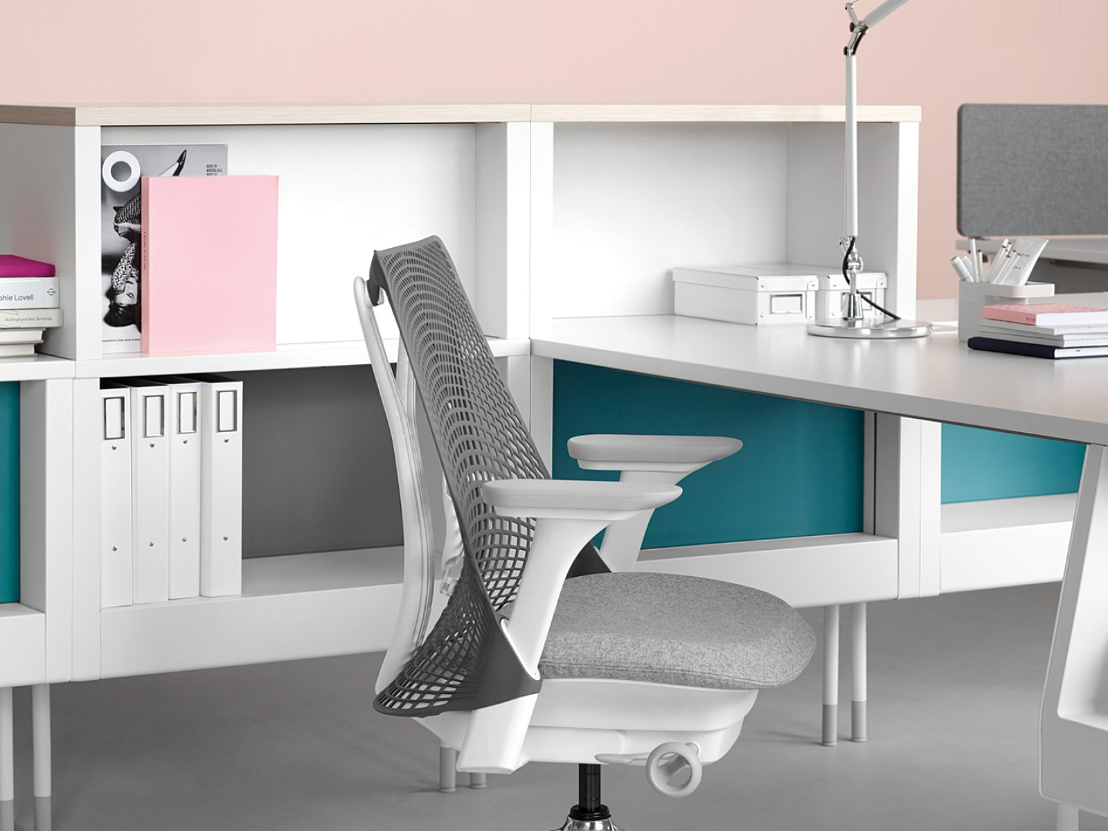 bright, clean photo of white and grey Herman Miller Sayl chair beside all white desk space