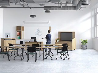 Person standing in classroom with mobile furniture and mobile technology