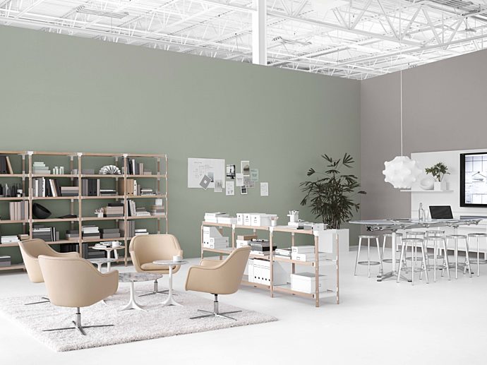 open plan office space. Left hand side with simple tan lounge chairs. Right side with a high top conference table and metal stools, tv on far right wall.
