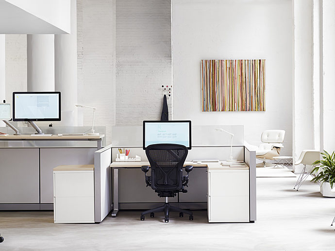 brightly lit office space. segmented desk space featuring the Herman Miller Aeron office chair in black.