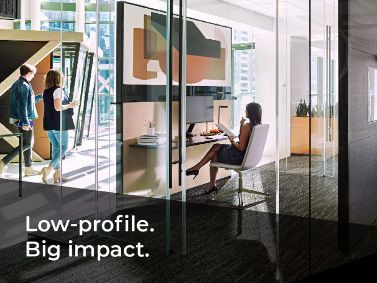 Picture of woman sitting at a desk in a room build out of new product line Reveal by DIRTT